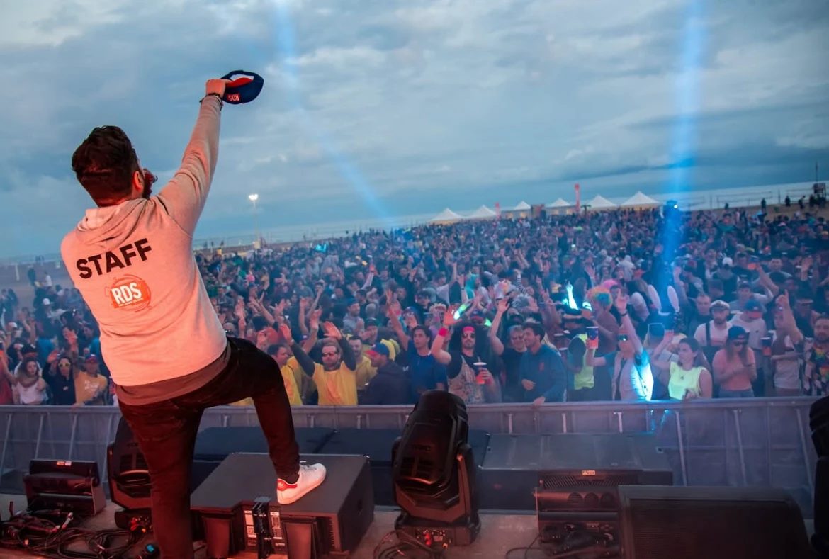 Staff sul palco di un festival davanti a una grande folla